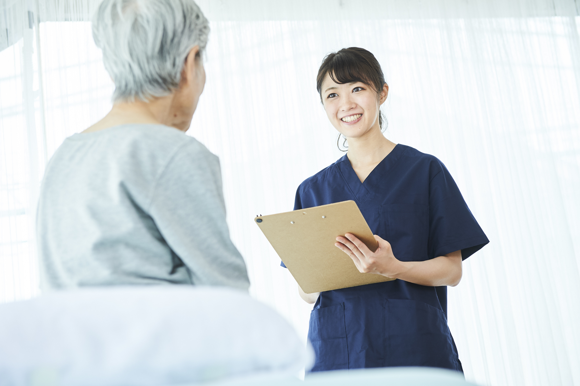 受付近くで予約表とタオルを整えながら、来院準備を進めているスタッフの自然な様子